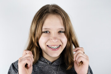 Portrait of a cute teen girl with dental braces on her teeth, the girl has blond hair and healthy teeth