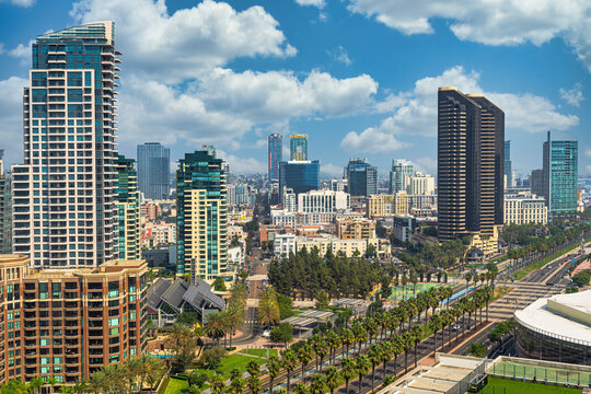 Aerial View Of The City Of San Deigo, CA Downtown Gaslamp District Skyline Filled With Skyscrapers, Hotels, Business Centers Against A Beautiful Vivid Cloud Filled Blue Sky