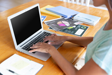 Fototapeta na wymiar Caucasian woman sitting by desk working from home using laptop