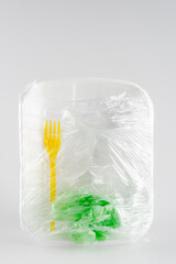 top view of plastic plate, fork and bag packed in cellophane, ecology concept