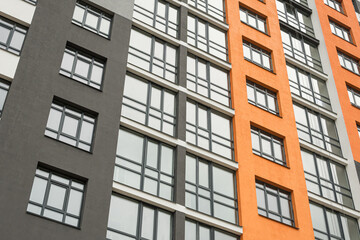 The facade of a multi-storey building with windows and balconies as an element of the architecture of a modern city