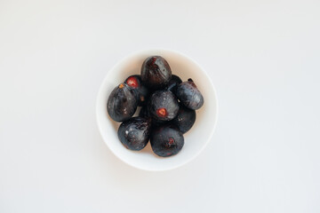 Ripe and sweet figs cut and arranged in a plate on a white background with free space. Fruits and vegetarianism