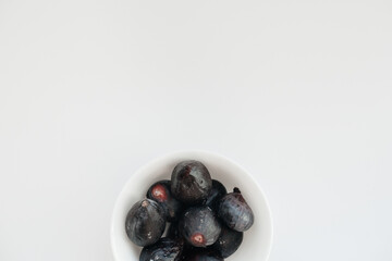 Ripe and sweet figs cut and arranged in a plate on a white background with free space. Fruits and vegetarianism