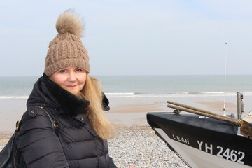 Cromer, Nortfolk, young lady looking at the camera, seaside and fishing boat in the background