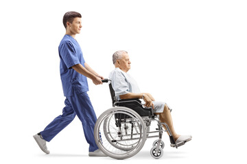 Full length profile shot of a young male nurse pushing a patient in a wheelchair