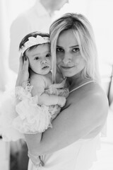 Mom holds her newborn daughter in her arms. Look at the camera. Black and White.