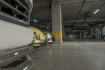 parking lot in the basement of a shopping mall and fronts of some cars parked