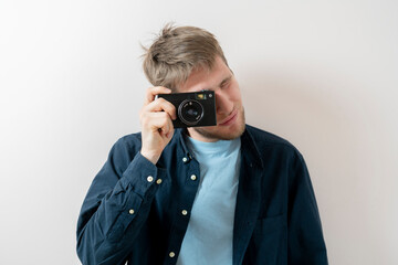 male person holding a vintage camera and djust settings, old fashioned trend