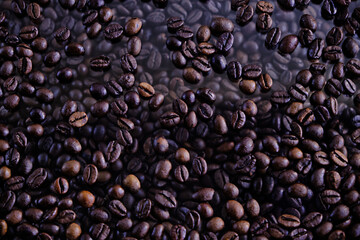 Whole coffee beans are on the glass