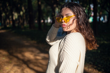 Relaxed happy woman in the park in summer climate. Portrait of a cute smiling woman outdoors. Concept of outdoor lifestyle. Latin girl power. Mexican young girl