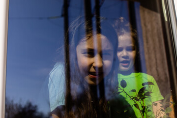 the happy girls look through the window on sunny day