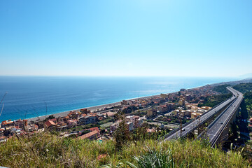 view on the Ionian coast with the typical coastal villages and the meandering highway. Mediterranean Sea. Sicily