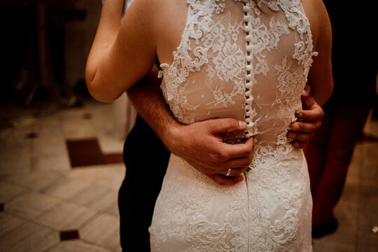 Midsection of a wedding couple slow dancing with groom's hands wrapped around bride's waist