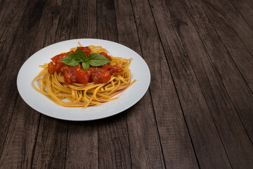 Pasta with rustic tomato sauce and basil leaves. Red sauce. Gastronomic photo of Italian food with space for text on the right. Bavette noodles.