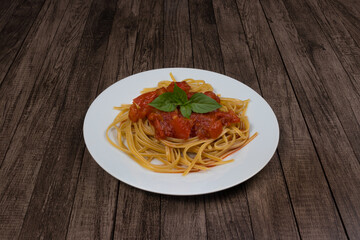 Pasta with rustic tomato sauce and basil leaves.Photograph with centralized elements and space for text. Gourmet photography. Typical food from Italy