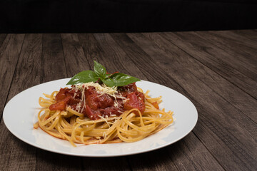 Pasta with rustic tomato sauce, basil leaves and grated cheese. Bavette pasta in red sauce with cheese. Photo with space for text. Italian gastronomy.