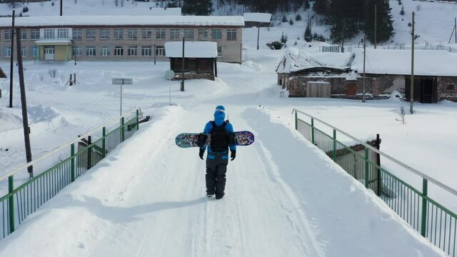 Aerial view of a snowboard crossing the bridge in winter