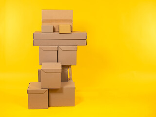 Boxes of different sizes are stacked. Cardboard boxes on a yellow background. These are parcels...