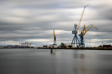 Fototapeta na wymiar Long exposure photograph of cranes in Belfast harbor, industrial shipyard.