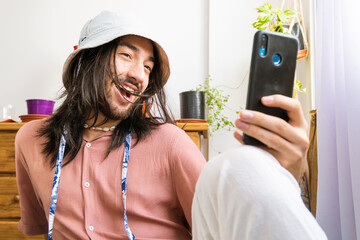 young hipster man taking a selfie in his house