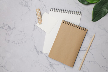 Two blank notepads with pencil on marble table