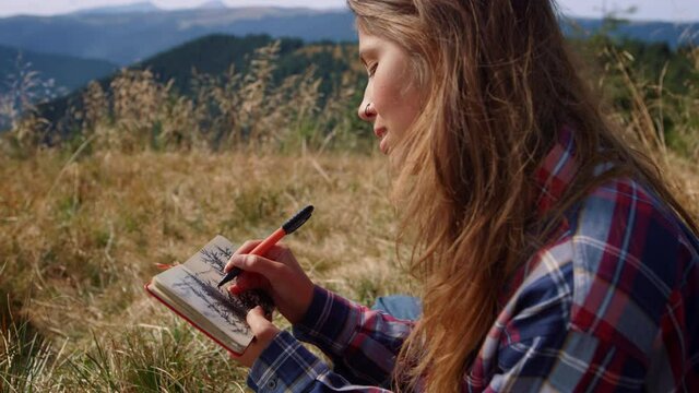 Woman drawing sketch of trees in notebook. Girl painting picture with pencil 
