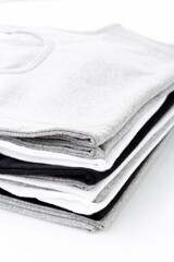 Close up of White, grey and black T-shirts folded group on background