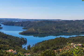 Fototapeta na wymiar Landscape view from the lake of the vacation spot of Castelo de Bode, Portugal. Viewpoint of Fontes with scenic view from the lake