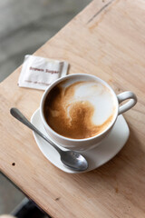 Cup of hot latte coffee on table