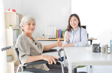 Obraz premium old Asian patient talk with female doctor and show thumb up sign with hand together, elderly health check up, happiness hospital