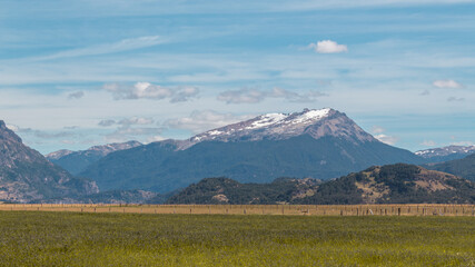Fototapeta premium Día soleado en el campo con montes de fondo.