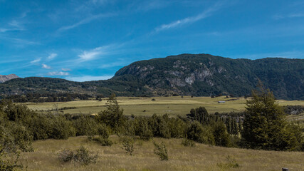 Día soleado en el campo con montes de fondo.