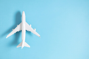 Airplane model. White plane on pastel blue background. Travel vacation concept. Summer background. Flat lay, top view, copy space