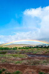 Double Rainbow in front of Maui Mountains on a cloudy day. 