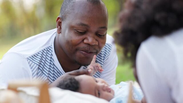 African American family Parents take care of cute baby in garden of house. Happy baby daughter. Father and mother Smile feel relax in playing with children. Concept Family health care insurance