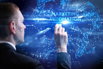 Business, Technology, Internet and network concept. Young businessman working on a virtual screen of the future and sees the inscription: Marketing automation