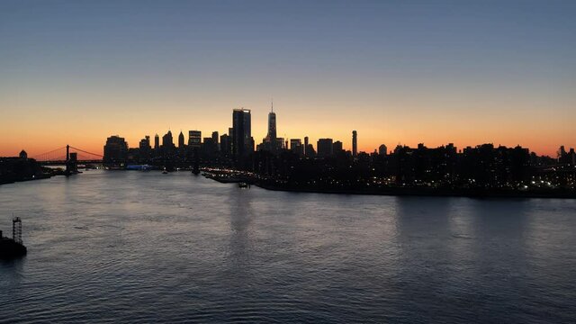 Manhattan skyline across East River Brooklyn Bridge water Freedom Tower sunset New York City NYC