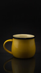 Tasa de metal amarilla con fondo negro.