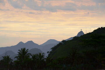 Piratininga Beach, in Niterói in Rio de Janeiro in the late afternoon with a beautiful view of the city of Rio de Janeiro and Christ the Redeemer. Sky with some orange clouds at the sunset.