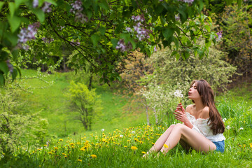 Naklejka na ściany i meble Spring happy woman sitting outdoor in park summer. Healthy breathing concept, unity with nature. Calm girl enjoy relax in spring air.