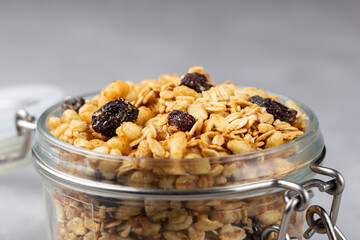 Glass jar with granola on the table.