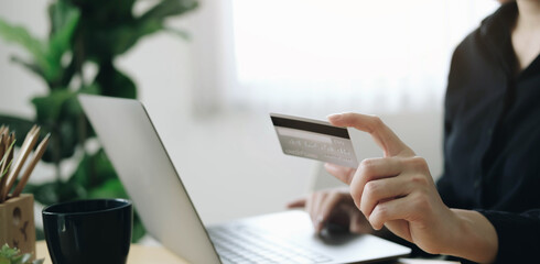 Fototapeta premium Hands holding credit card and using laptop. Online shopping