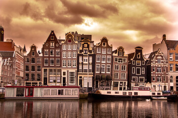 famous amsterdam canal with typical houses in the back