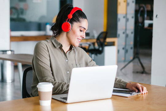 mexican woman working with computer and headphones at the office or workplace in Mexico city