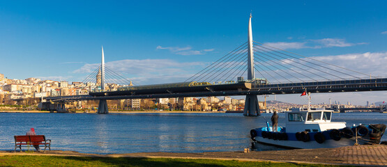 Fototapeta premium Scenic view of cable-stayed metro bridge across Golden Horn with modern cityscape of Beyoglu district of Istanbul on sunny day, Turkey.