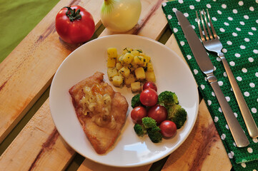 Delicious chicken fillet accompanied by tomato, broccoli, potatoes.