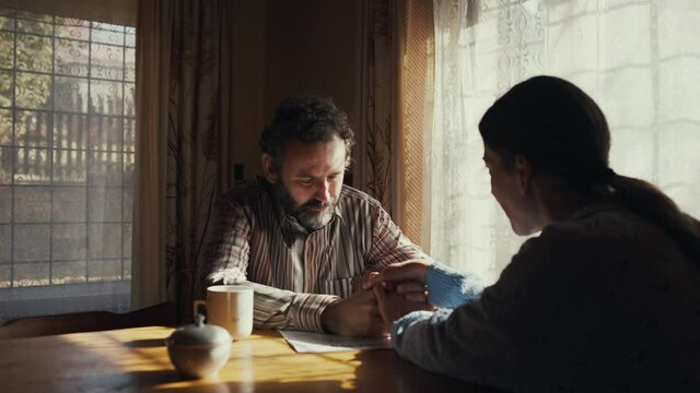 Unhappy poor couple comforting each other indoors at home, poverty concept.