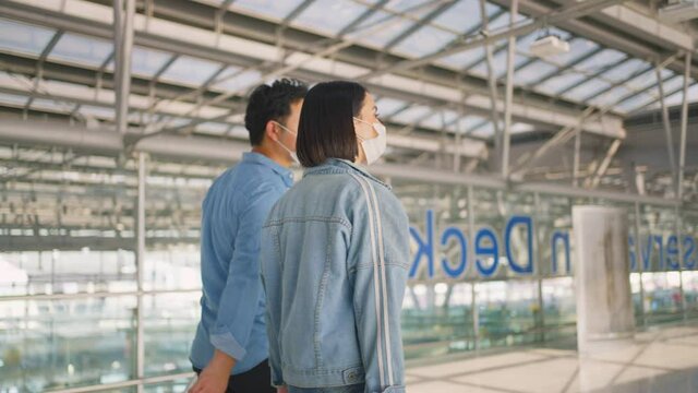 Couple of Asian passenger dragging suitcase walk in passenger terminal