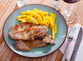 Grilled barbecue pork meat with baked potato and dip on a plate