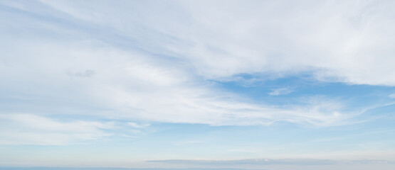 Blue sky against soft white clouds. Beautiful natural cloudscape background.